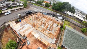 Modern new home construction site in Honolulu Oahu with framing and coastal backdrop