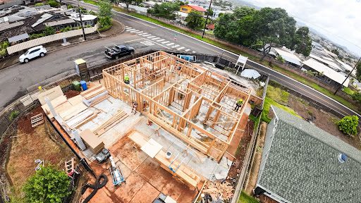 Modern new home construction site in Honolulu Oahu with framing and coastal backdrop